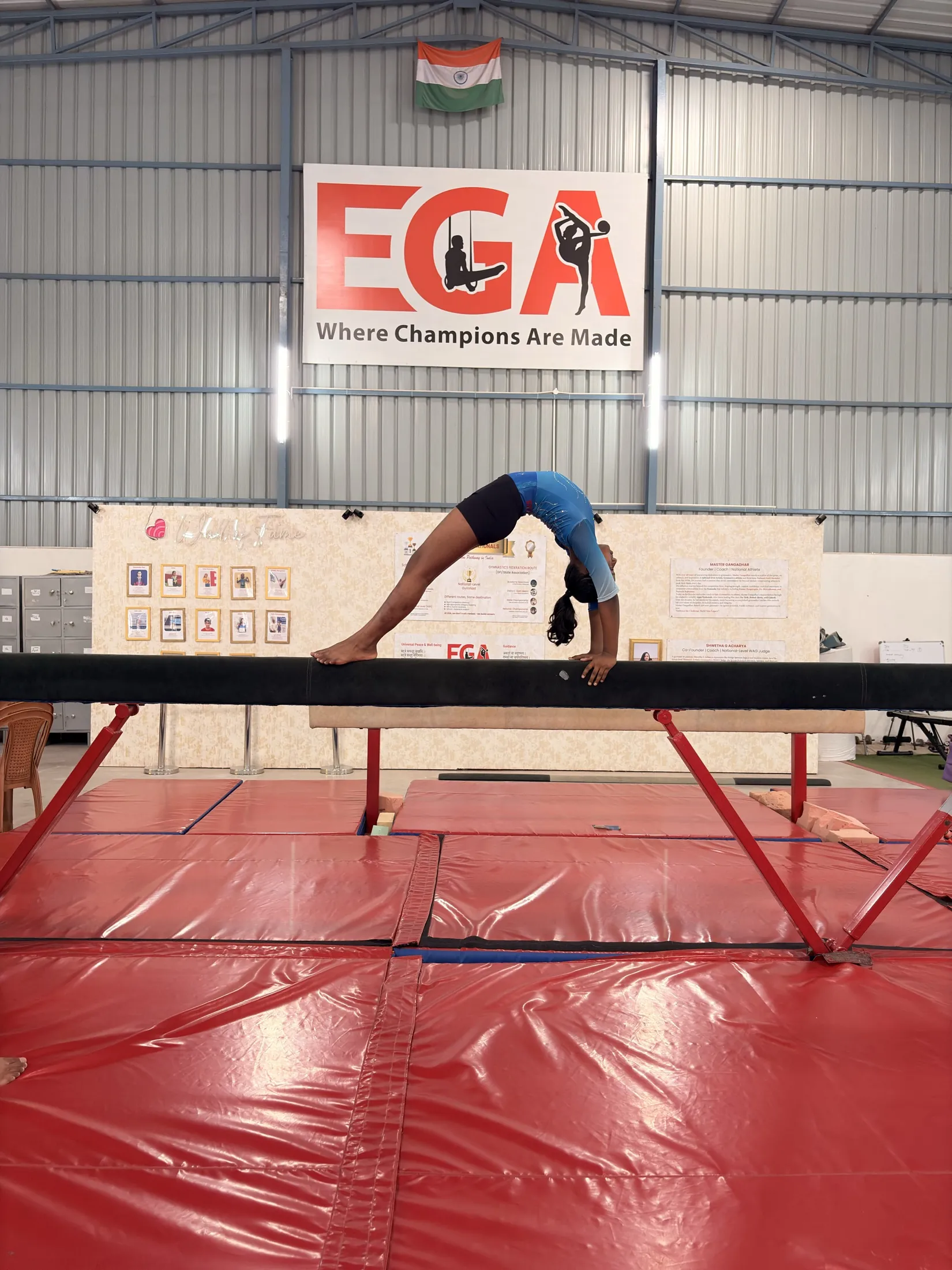 Gymnast in a bridge on the balance beam at EGA