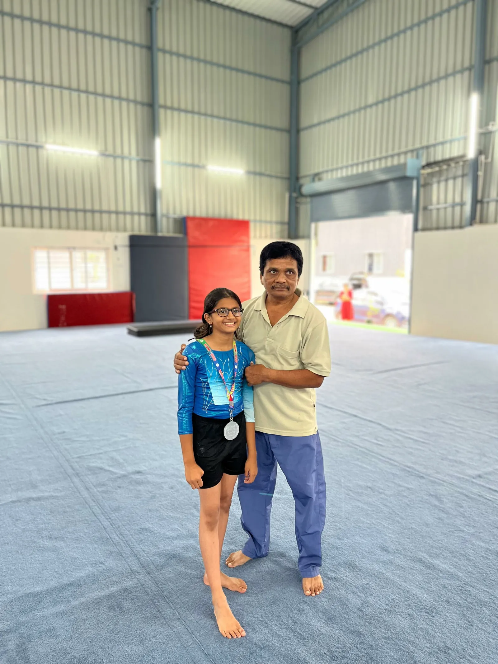 EGA gymnast with a medal and her coach